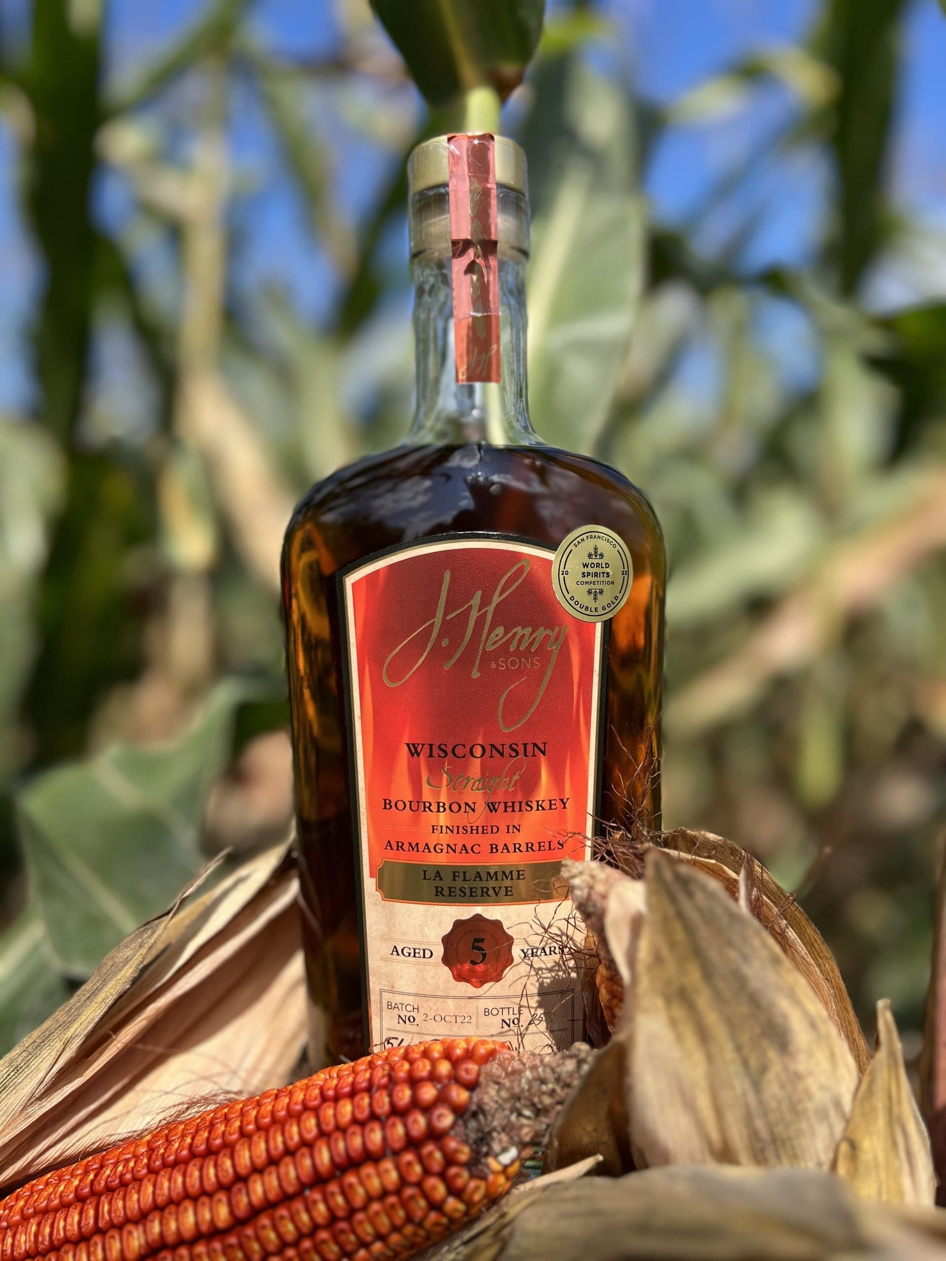 La Flamme 酒瓶置於 Henry 家族紅玉米田中,旁有傳家紅玉米